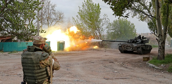 Service members of pro-Russian troops fire from a tank in Mariupol